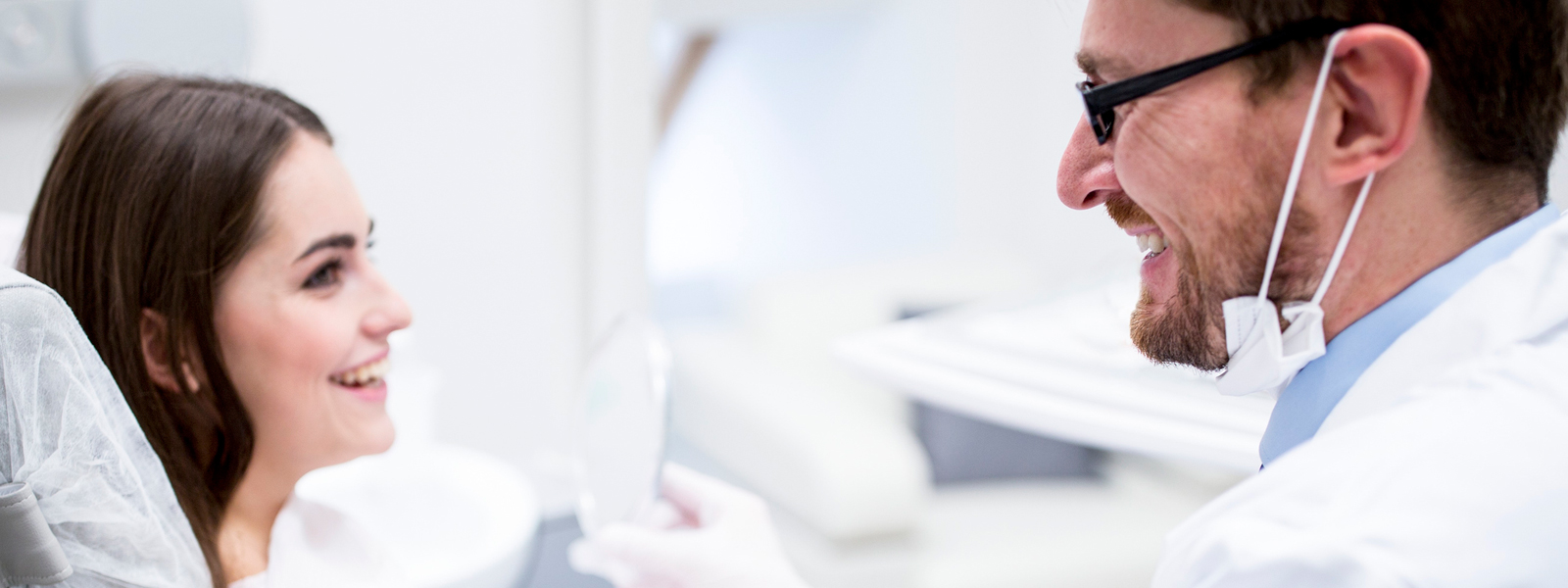 ACDQ Dentist smiling to sitting patient